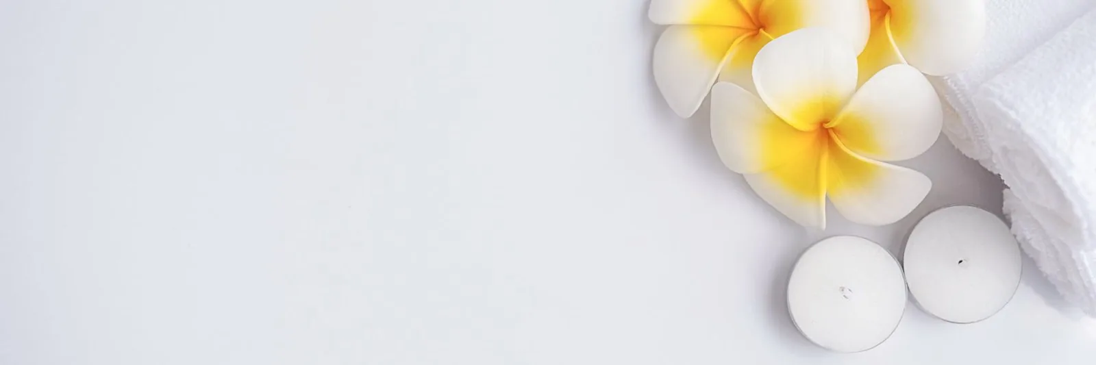 Candles and frangipani flowers on a spa tray