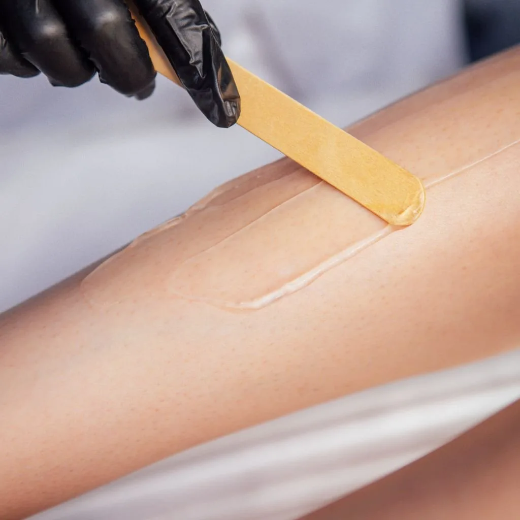 Warm wax applied to a client's forearm