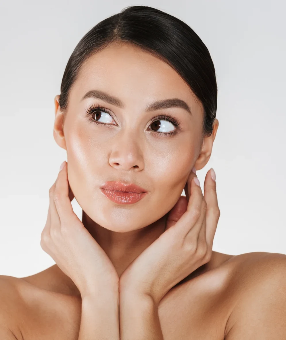A client with clear skin resting her hands against her jaw